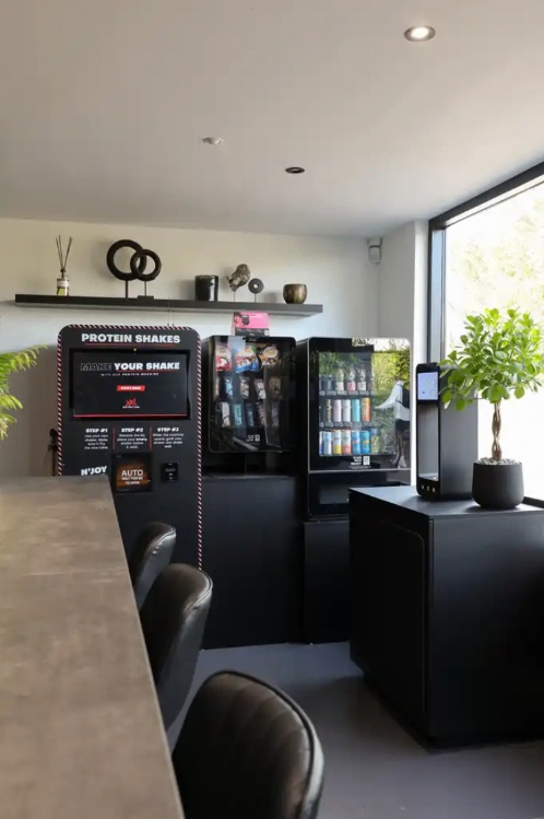 Lichte ontvangstruimte van Vital-GO met bar, zitplaatsen en automaten.